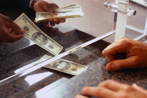 Bank Teller Counting Money for Customer --- Image by © Duncan Smith/Corbis